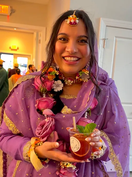Bride in lilac mehndi outfit holding a Talab Sips mocktail