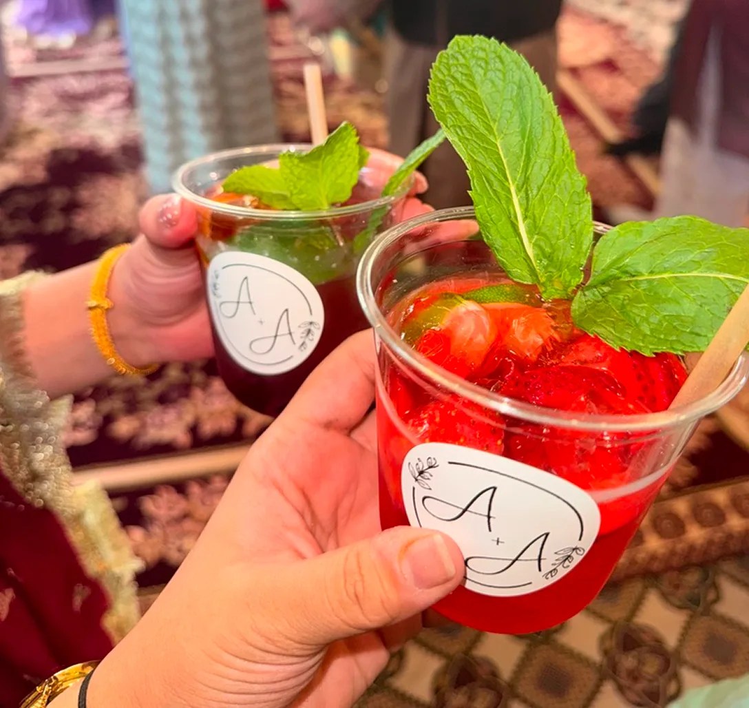 Two hands cheers-ing strawberry mocktails